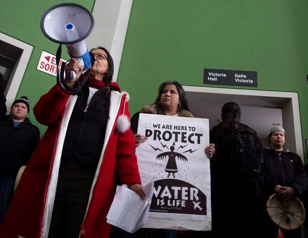 Protesters stand outside the room where the Prime Minister Justin Trudeau was scheduled to speak in Ottawa, Tuesday January 8, 2019. 