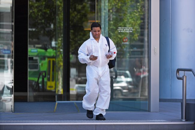 A man wearing hazardous materials suit is seen exiting the building where the South Korean consulate is located in Melbourne, Victoria, Australia, 09 January 2019.