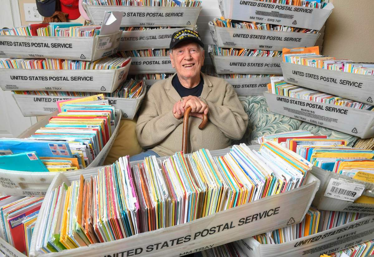 In this Tuesday, Jan. 8, 2019 photo, Duane Sherman, 96, poses at home with a small fraction of the 50,000 birthday cards he's received after his daughter's social media request for people to send him cards to cheer him up on his birthday went viral in Fullerton, Calif. 