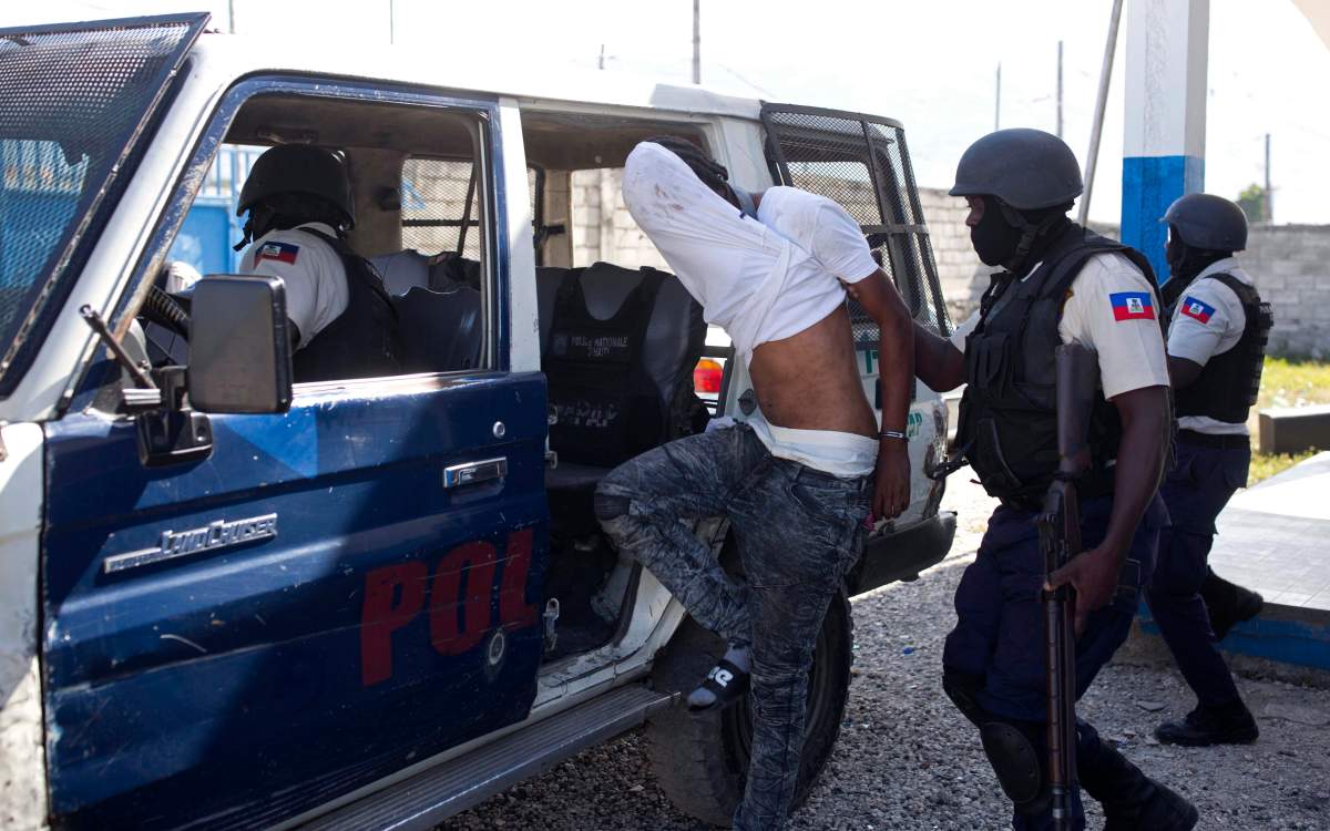 In this Dec. 10, 2018, photo, police arrest an alleged gang member whom residents of La Saline slum identify as one of the perpetrators of the massacre in their slum of Port-au-Prince, Haiti. The Nov. 13 massacre revealed a startling degradation of security in Haiti since UN peacekeepers ended their 13-year mandate in 2017 because conditions on the island had supposedly improved.