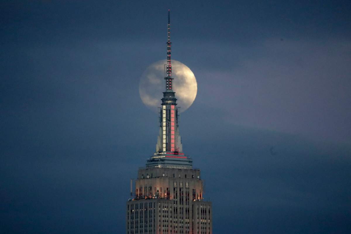 The moon is seen in its waxing gibbous stage as it rises behind the Empire State Building, on Sunday, Jan. 20, 2019.
