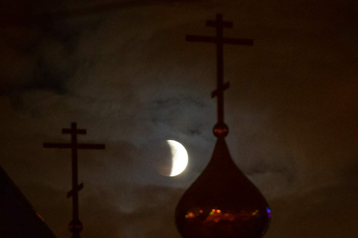 A lunar eclipse progresses behind a Russian Orthodox Church in Moscow, Russia, on Monday, Jan. 21, 2019.