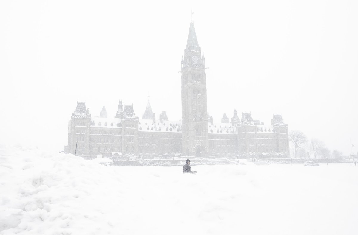 A pedestrian walks past a snowbank on Parliament Hill in Ottawa on Sunday, January 20, 2019. Environment Canada issued a winter storm warning for the city of Ottawa on Wednesday, Jan. 23, 2019.