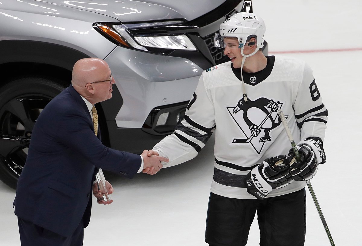 Metropolitan Division's Sidney Crosby, right, of the Pittsburgh Penguins, is congratulated by NHL Deputy Commissioner Bill Daly after being named the Most Valuable Player of the NHL hockey All-Star Game in San Jose, Calif., Saturday, Jan. 26, 2019. The Metropolitan Division defeated the Central Division 10-5 in the final. (AP Photo/Jeff Chiu).