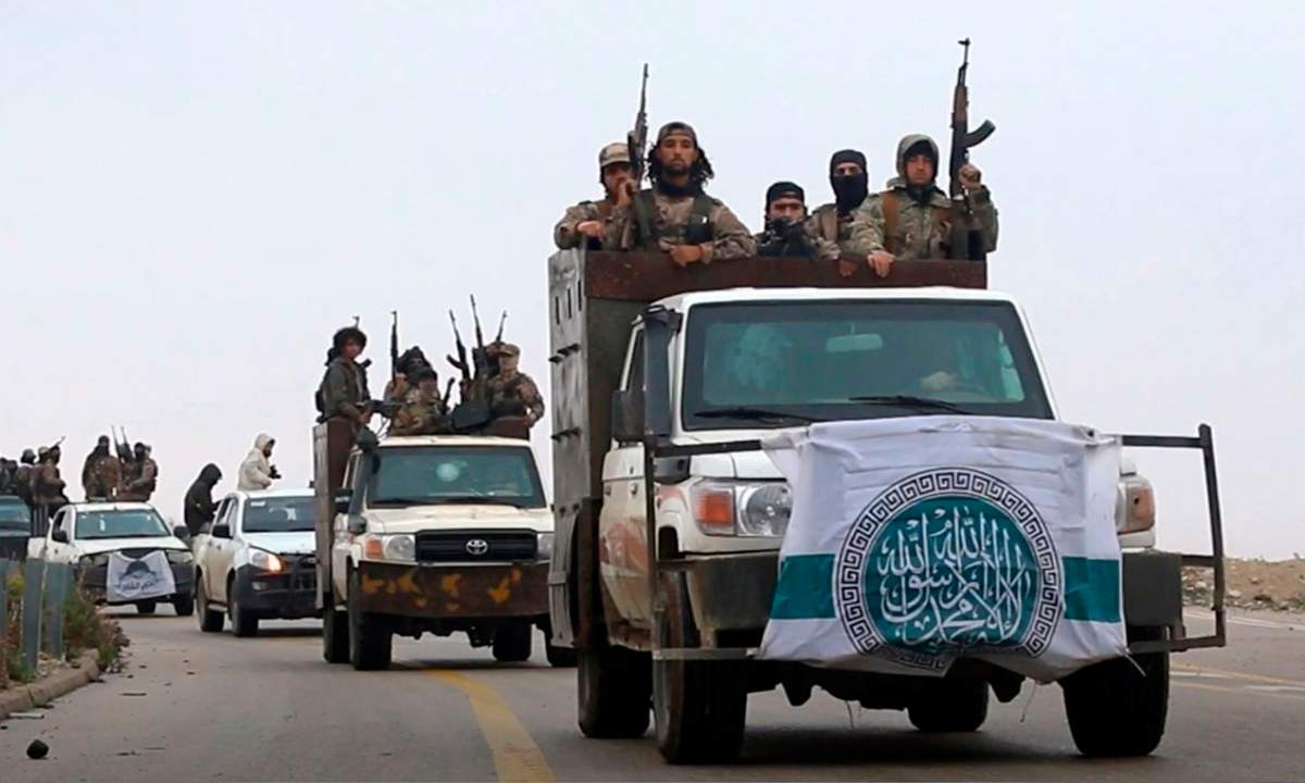 This photo released Dec. 4, 2018 by the al-Qaida-affiliated Ibaa News Agency, shows al-Qaida-linked fighters driving their vehicles during a military drill in northern Syria. 