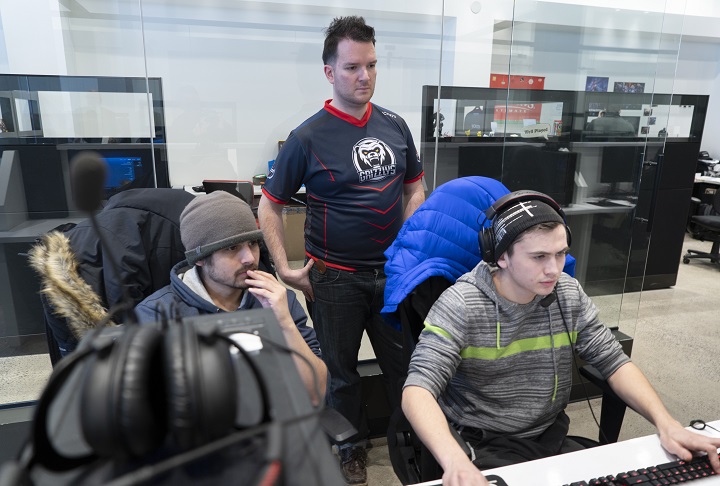Patrick Rheaume-Espinoza, operations director for the Montreal Esports Academy, oversees head trainer Antonin Tran, left, working with student Eliyakim Bezeau in Montreal on Thursday, January 31, 2019. 