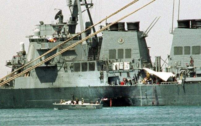 A small boat guards the USS Cole in Aden, Yemen Friday Oct. 20 2000.