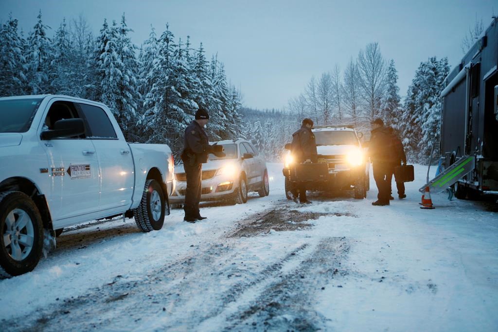 RCMP officers switch between shifts near their roadblock as supporters of the Unist'ot'en camp and Wet'suwet'en First Nation gather at a camp fire off a logging road near Houston, B.C., on Wednesday, January 9, 2019.