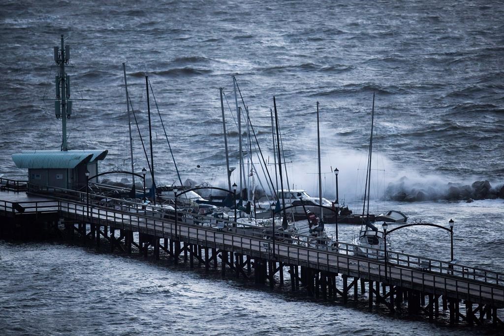 Boats are battered by waves at the end of the White Rock Pier that was severely damaged during a windstorm, in White Rock, B.C., on December 20, 2018.
