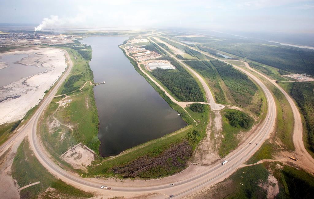 A highway loops around a tailings pond at the Syncrude facility as seen from a helicopter tour of the oil sands near Fort McMurray, Alta., on July 10, 2012.  THE CANADIAN PRESS/Jeff McIntosh.