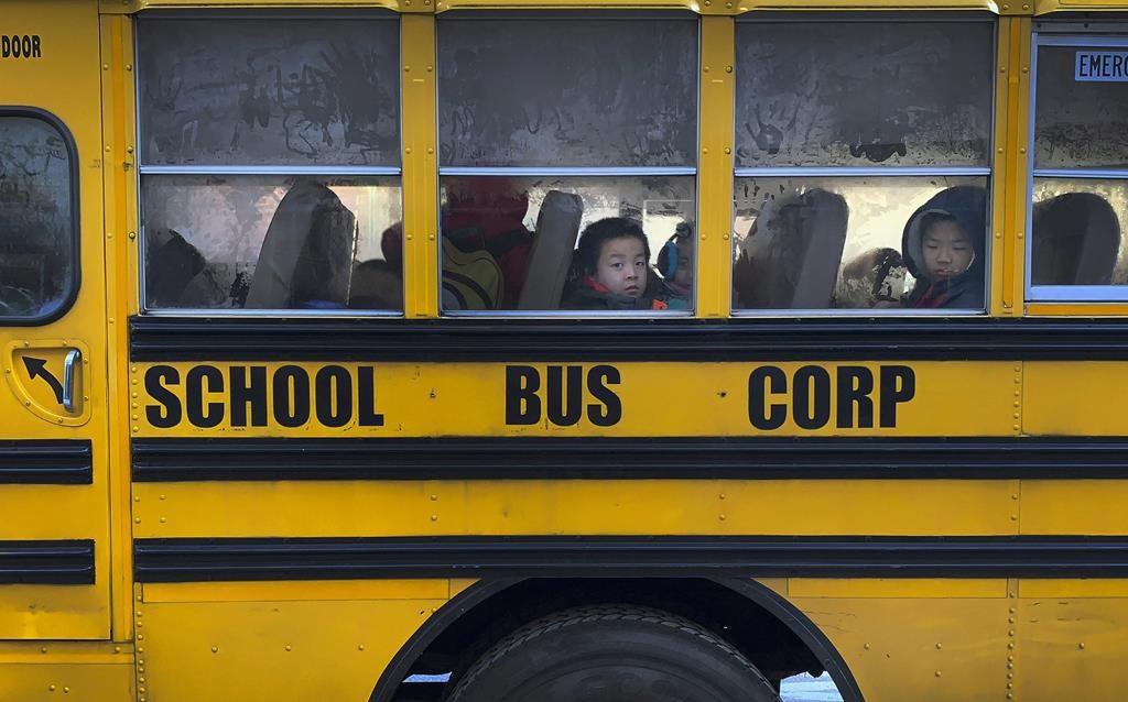 Another day begins on the yellow bus, as children peer through fogged-over windows on their way to school.