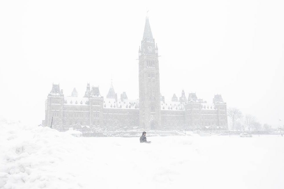 A pedestrian walks past a snowbank on Parliament Hill in Ottawa on Sunday, January 20, 2019.