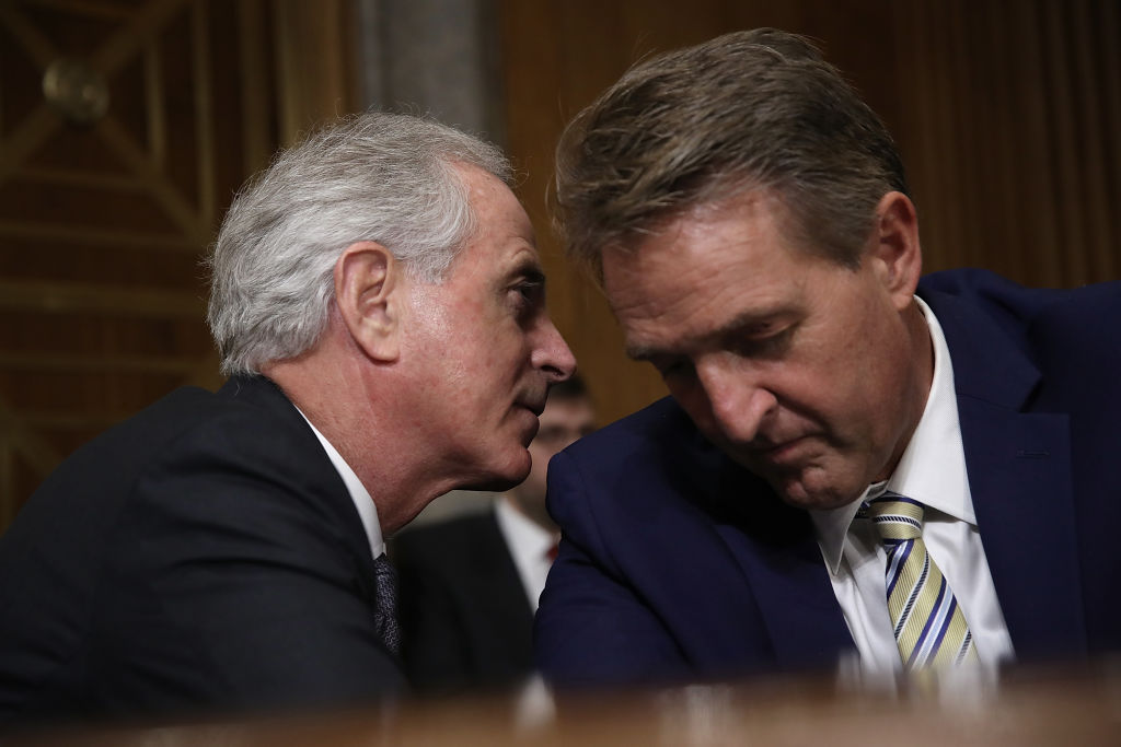 Sen. Bob Corker (L) confers with Sen. Jeff Flake during a Senate Foreign Relations Committee hearing Nov. 14, 2017 in Washington, DC.