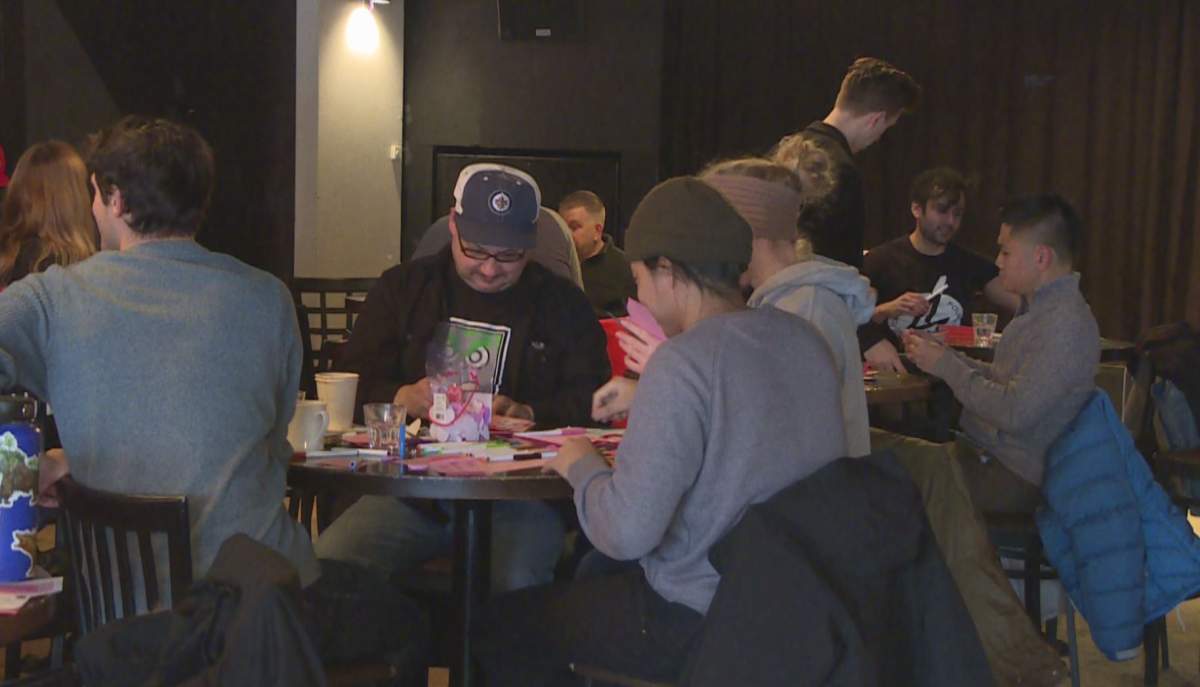 A group of men crafting Valentine\’s Days cards at the Goodwill Social Club on Portage Avenue.