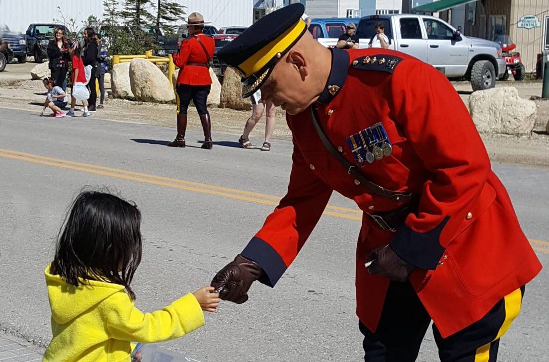 Assistant Commissioner Scott Kolody of the Manitoba RCMP shakes hands with a little girl in Churchill.