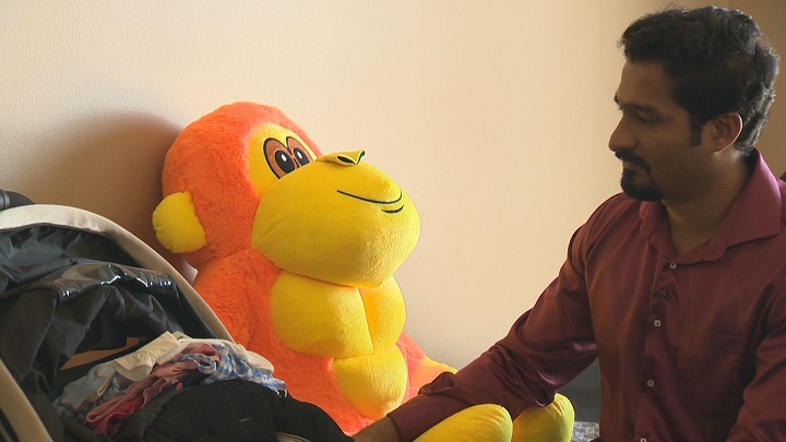 Robin Roy sits by a stroller full of clothes he purchased for his daughter in Winnipeg.