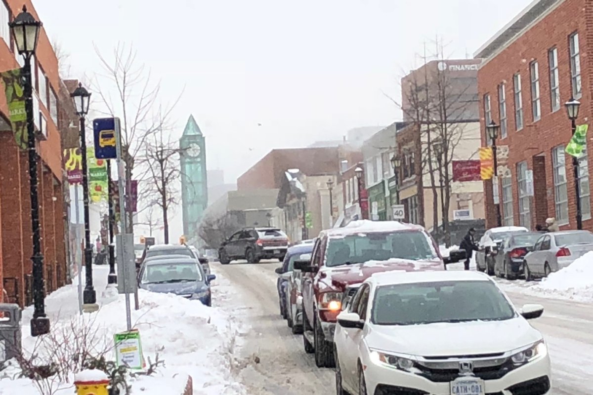 The clock from Market Square Shopping Centre can be seen as the snow falls on King Street in Kitchener.
