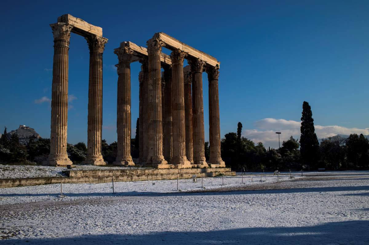 This picture taken on January 8, 2019 in Athens shows the archaeological site of the ancient Temple of Zeus following a snowfall over the Greek capital.