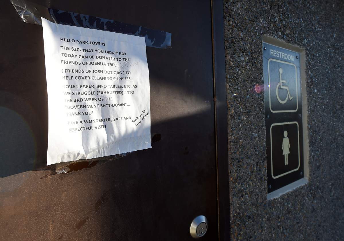 A sign posted on a Joshua Tree National Park restroom asks for donations towards the clean-up of the park on Thursday.