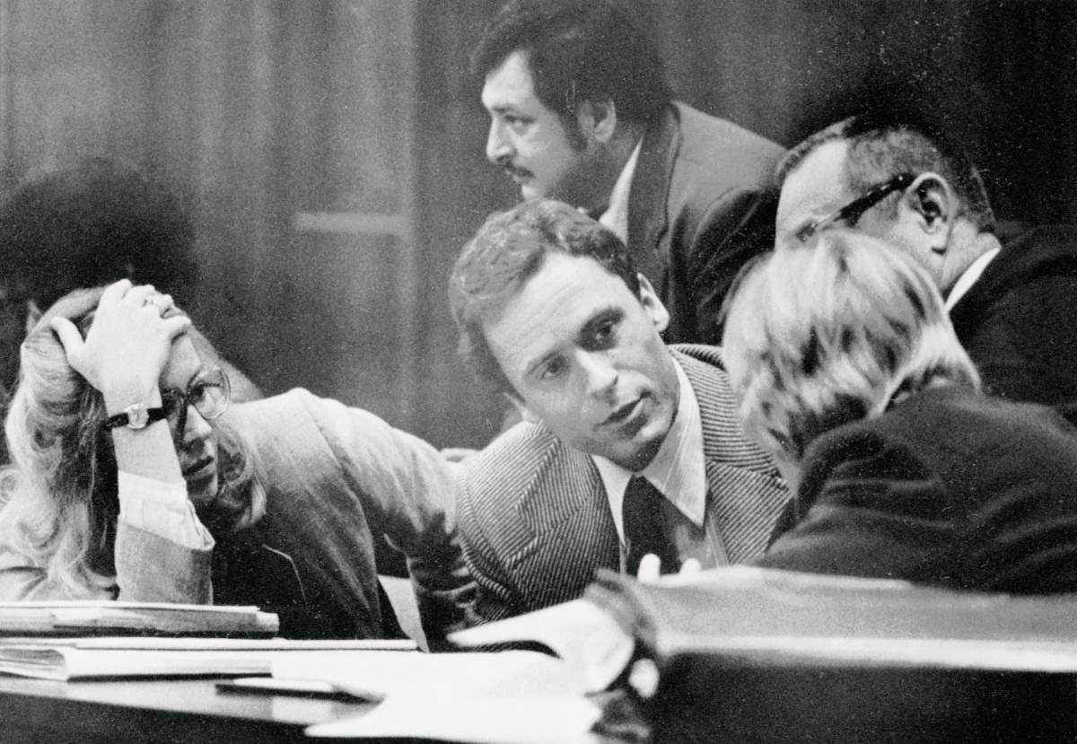 Theodore Bundy (C) confers with his defence attorneys on the opening day of his trial.