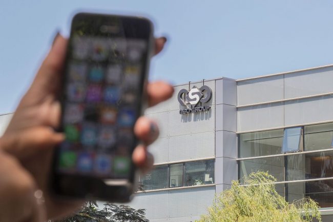 An Israeli woman uses her iPhone in front of the building housing the Israeli NSO group, on August 28, 2016, in Herzliya, near Tel Aviv.