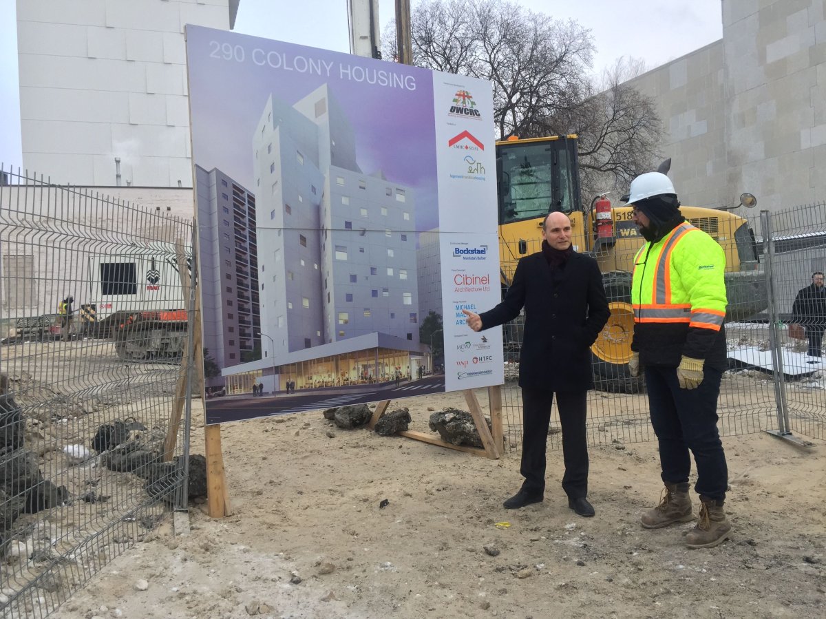 Jean-Yves Duclos, federal minister of families, shows off the rendering of the building at 290 Colony. It will be filled with affordable apartment units.