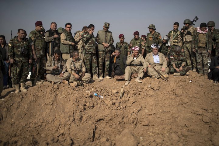In this Nov. 7, 2016 file photo, Kurdish Peshmerga fighters and commanders overlook Islamic State group positions during heavy fighting in Bashiqa, east of Mosul, Iraq.