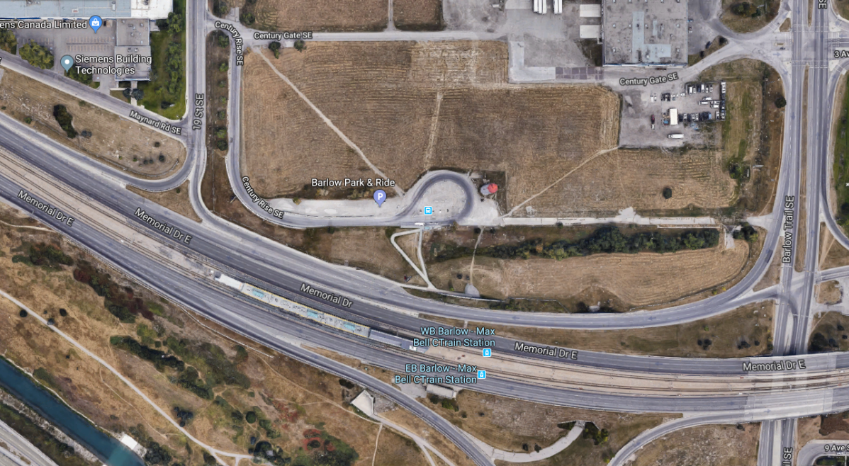 The Max Bell CTrain station and nearby bus stop. A pedestrian path cuts through an empty field.