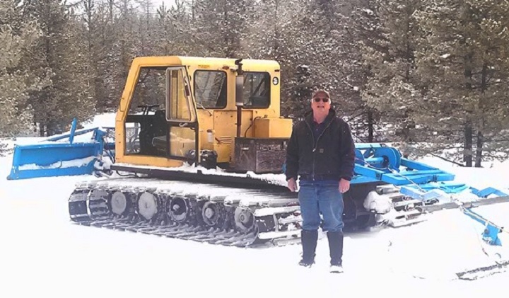 A member of the McKinney Nordic Ski Club stands near the organization’s snowcat. The club is reporting that several items have been stolen recently, including gas and the battery from the snowcat.