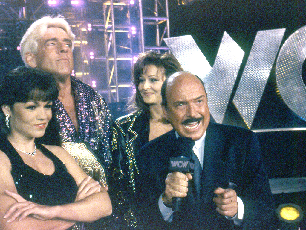 (L-R) Woman, Ric Flair, Miss Elizabeth and Gene Okerlund circa 1998 during a WCW braodcast.