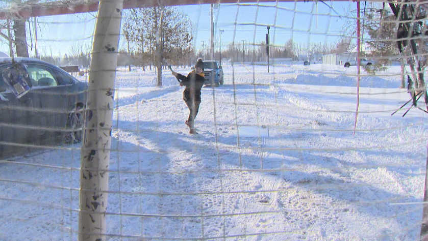 Trinity Grove, 15, shooting pucks on her front driveway across the street from the St. Andrews Community Club rink.