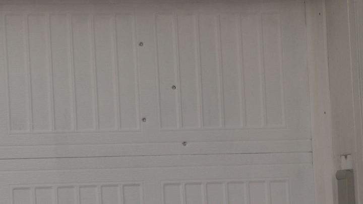 Bullet holes can be seen in a garage door in northeast Calgary on Sunday, after reports of shots fired.