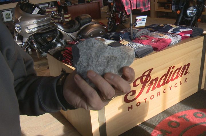 Vince Aiello, the general manager of Indian Motorcycles of Calgary, holds the rock that was thrown through his shop’s doors in a smash and grab on Tuesday morning.