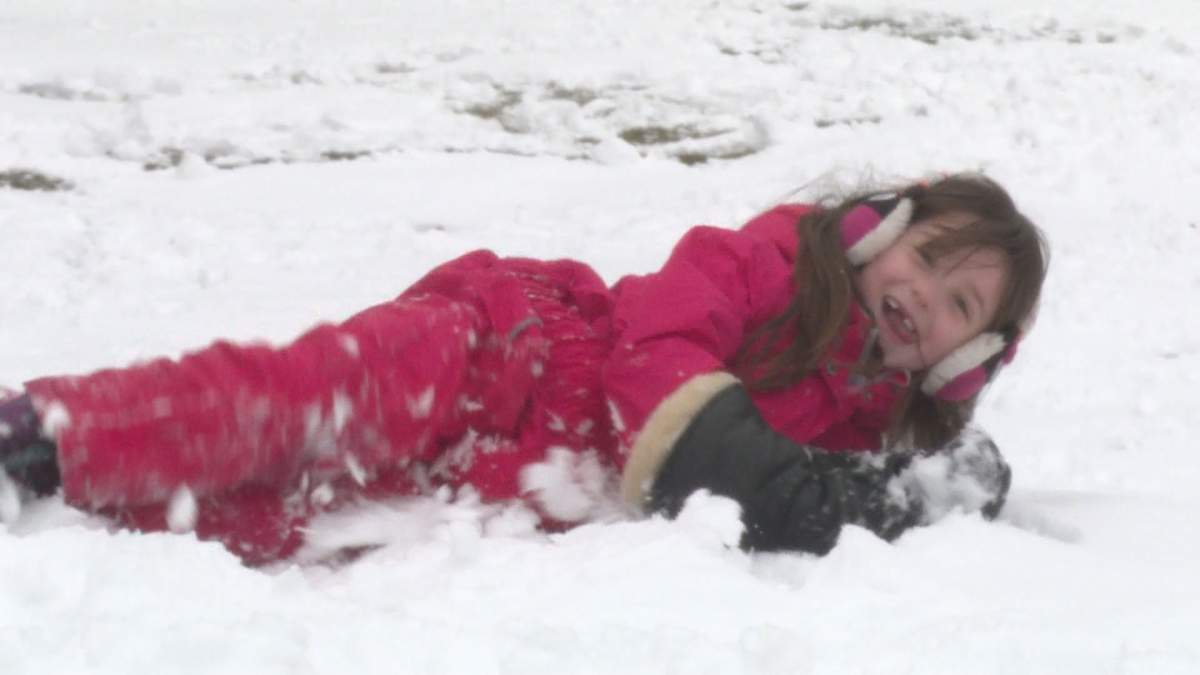 Member of the Brunet family rolls in the snow.