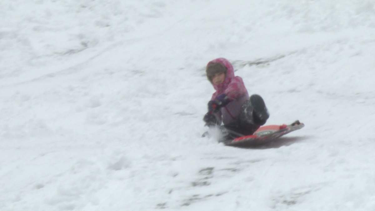Tobogganers slides down snow covered hill at the Beaconsfield Golf Course.