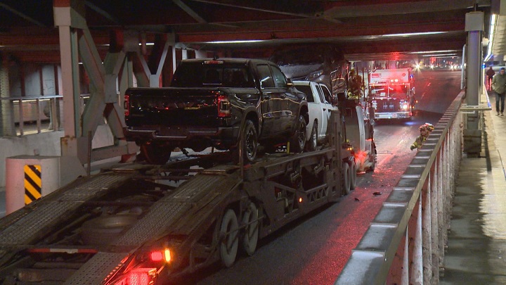 A transport truck carrying multiple vehicles ended up wedged under a Calgary underpass.