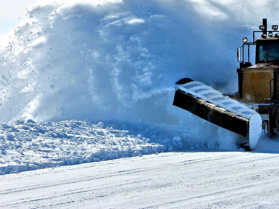 A snowplow tackles a city of Winnipeg street.
