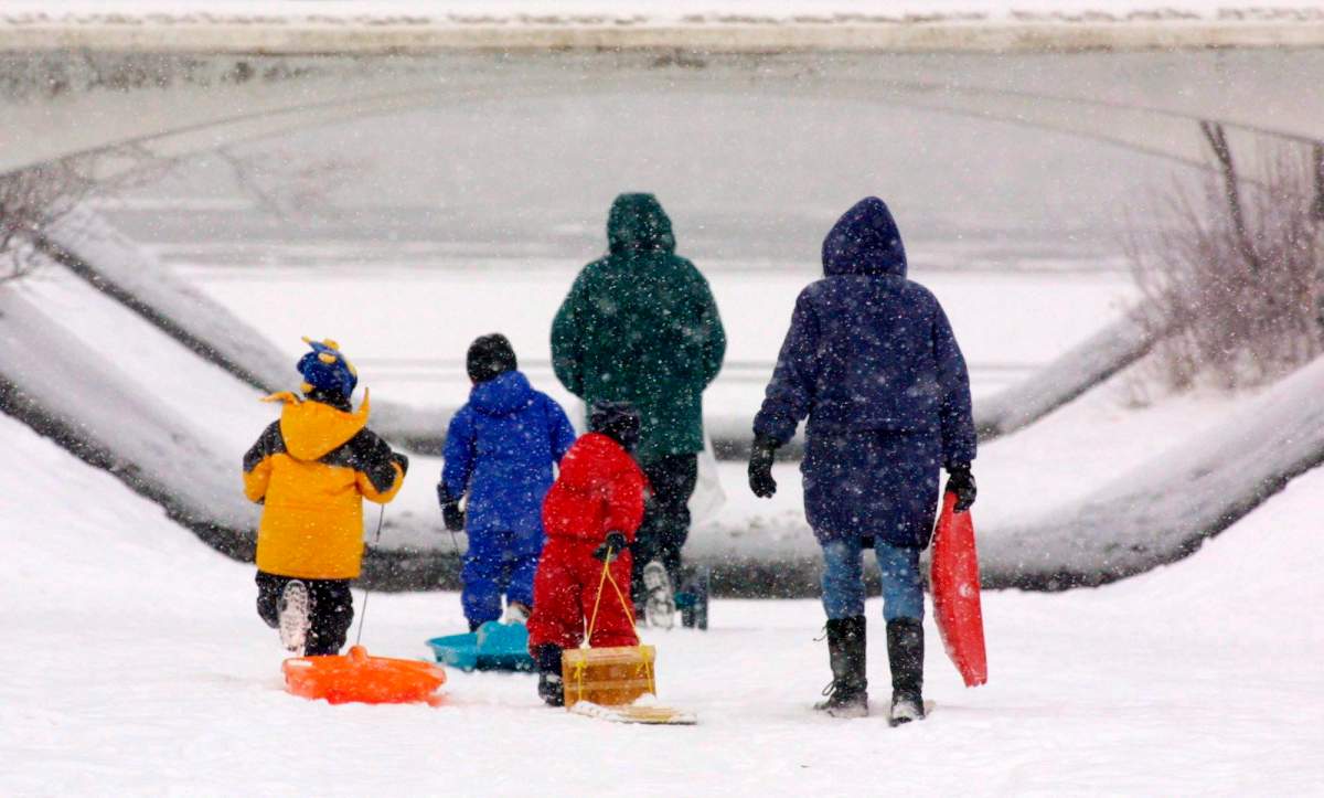 A family makes their way through the freshly fallen snow to go tobogganing in downtown Ottawa Friday, Dec. 28, 2001.