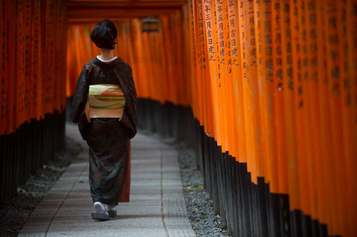 A Japanese woman clad in kimono walks through a series of Shinto torii gates at Fushimi Inari Shrine in Kyoto, Japan, on Oct. 24, 2017. 