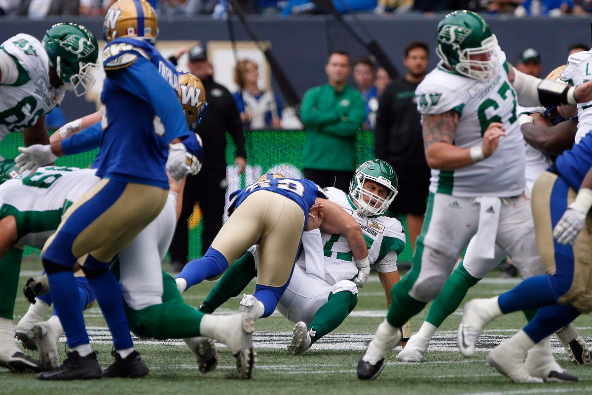 Saskatchewan Roughriders quarterback Zach Collaros (17) gets hit by Winnipeg Blue Bombers' Jeff Hecht (29) during second half CFL action in the 15th annual Banjo Bowl in Winnipeg Saturday, September 8, 2018. 