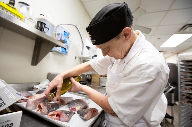 Sue McAdam prepares to cook tilapia fish, from an aquaponics grow operation by licensed marijuana producer Green Relief, at Good Shepherd Ministries homeless shelter’s soup kitchen in Toronto, Ont., Jan. 27, 2019.