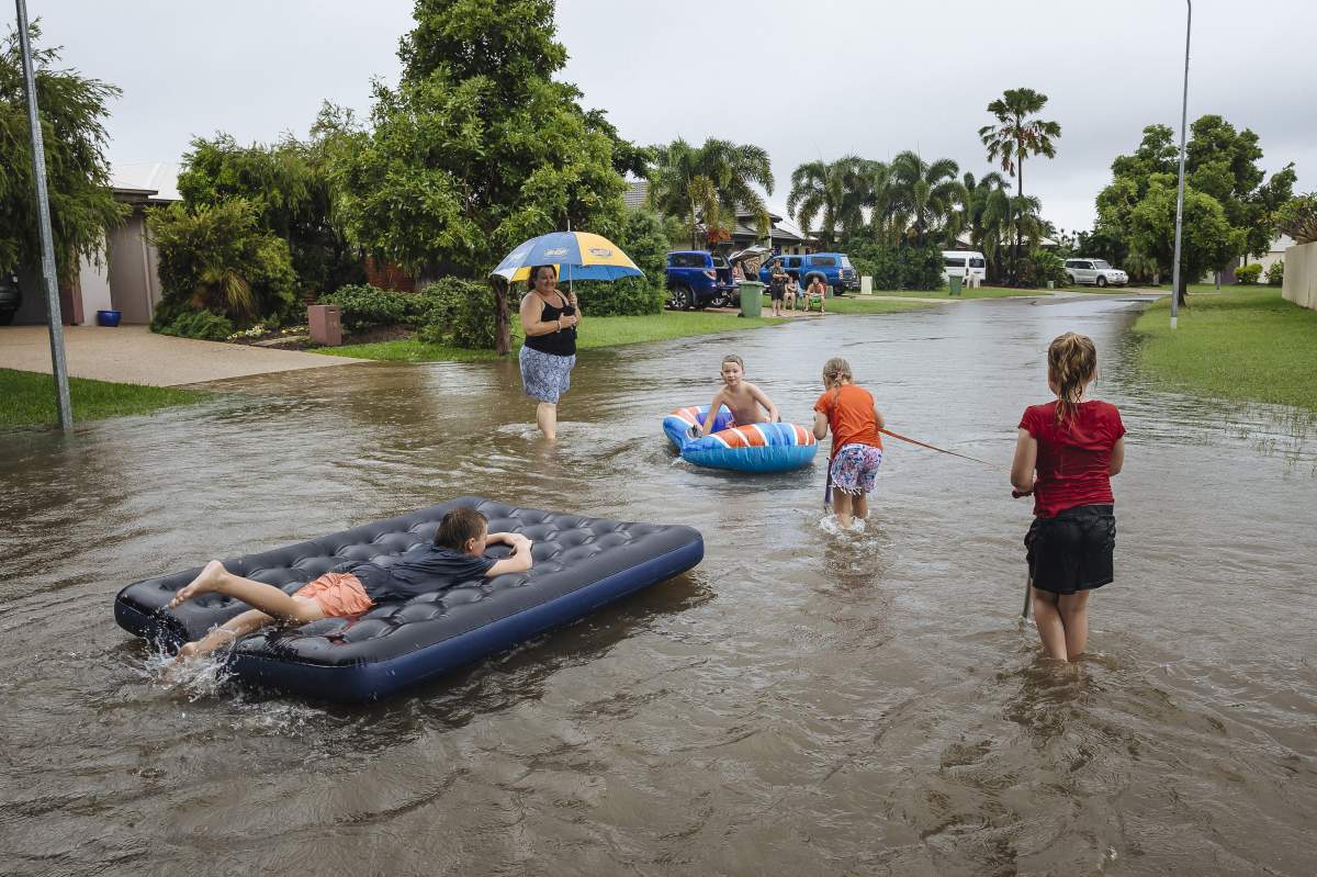 Residents of the suburb of Idalia are seen playing in floodwaters in Townsville, Queensland, Australia, Feb. 1, 2019.
