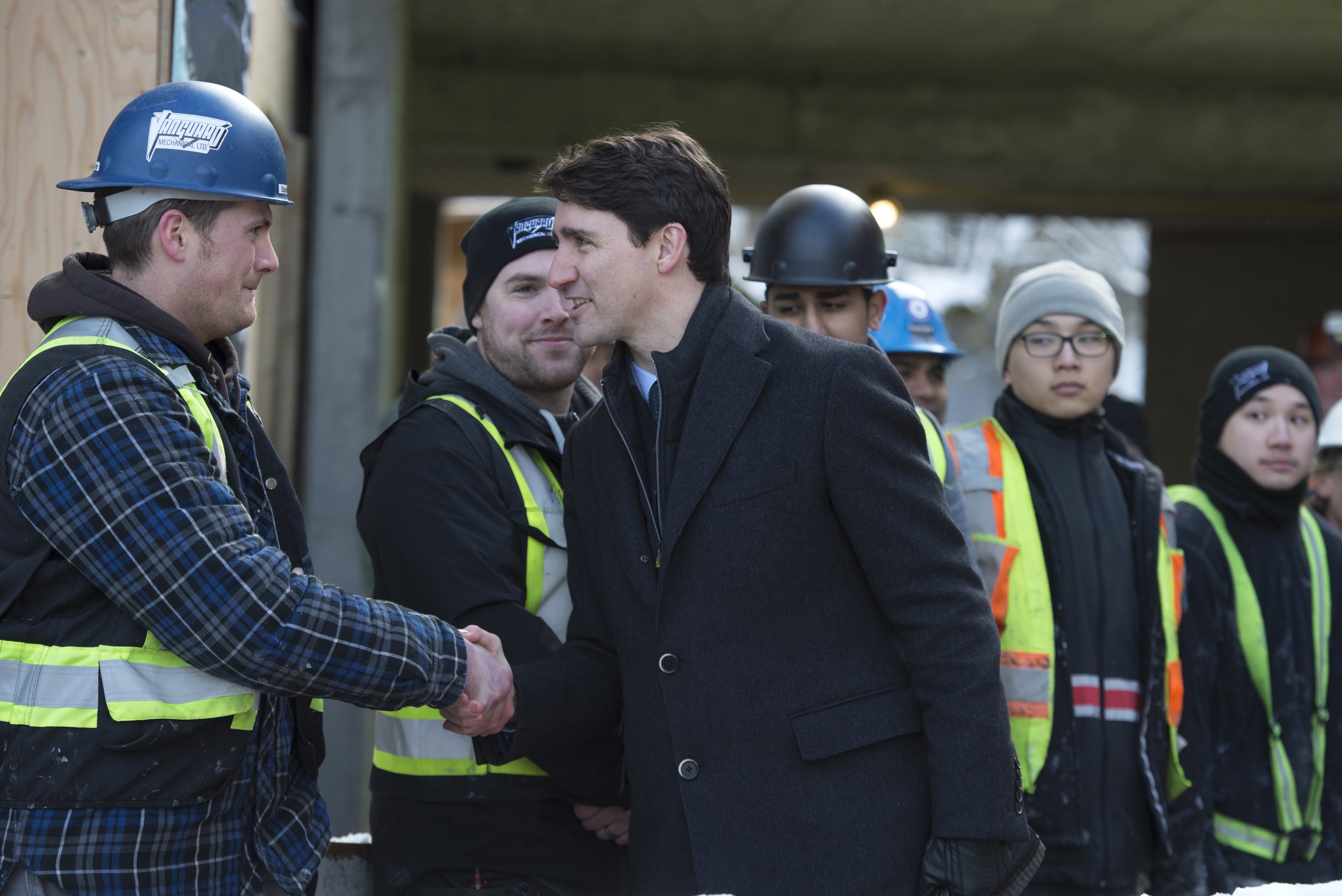 Prime Minister Justin Trudeau greets workers as he tours the Conrad rental housing development in Vancouver, Monday, Feb. 11, 2019. 
