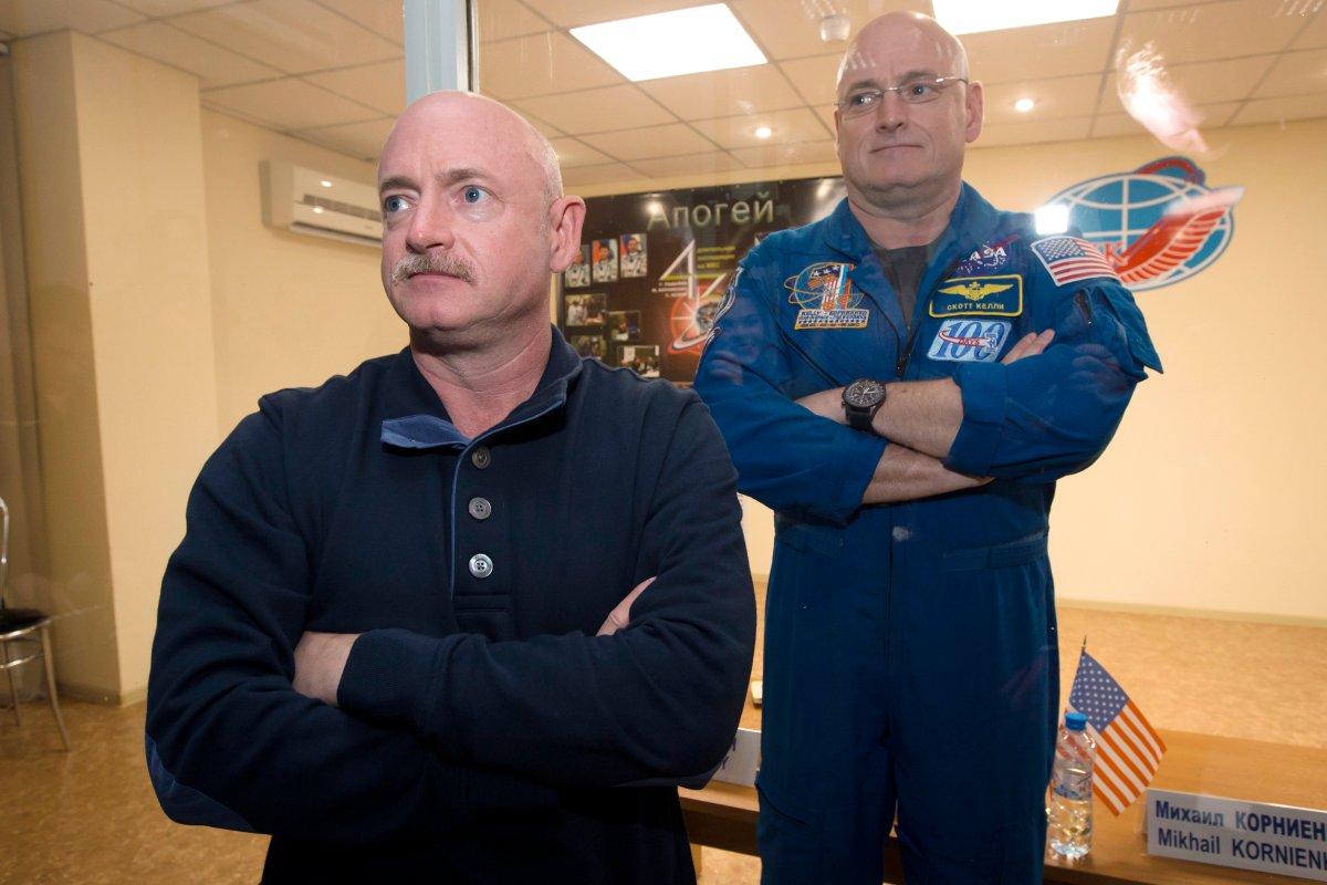 FILE - In this March 26, 2015 file photo, U.S. astronaut Scott Kelly, right, crew member of the mission to the International Space Station, stands behind glass in a quarantine room, behind his brother, Mark Kelly, also an astronaut, after a news conference in the Russian-leased Baikonur, Kazakhstan cosmodrome.