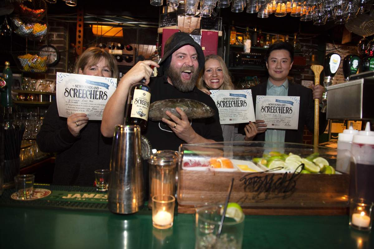 Emma Hall, left to right, Herfordshire, UK, Brian Day (Officiate) Roxanne Logan, Johannesburg, South Africa and Kangyn Wang of China display their official certificate following their “ScreechIn” by Brian Day at Christian’s Pub on Wednesday February 13, 2019 in St. John’s NL.