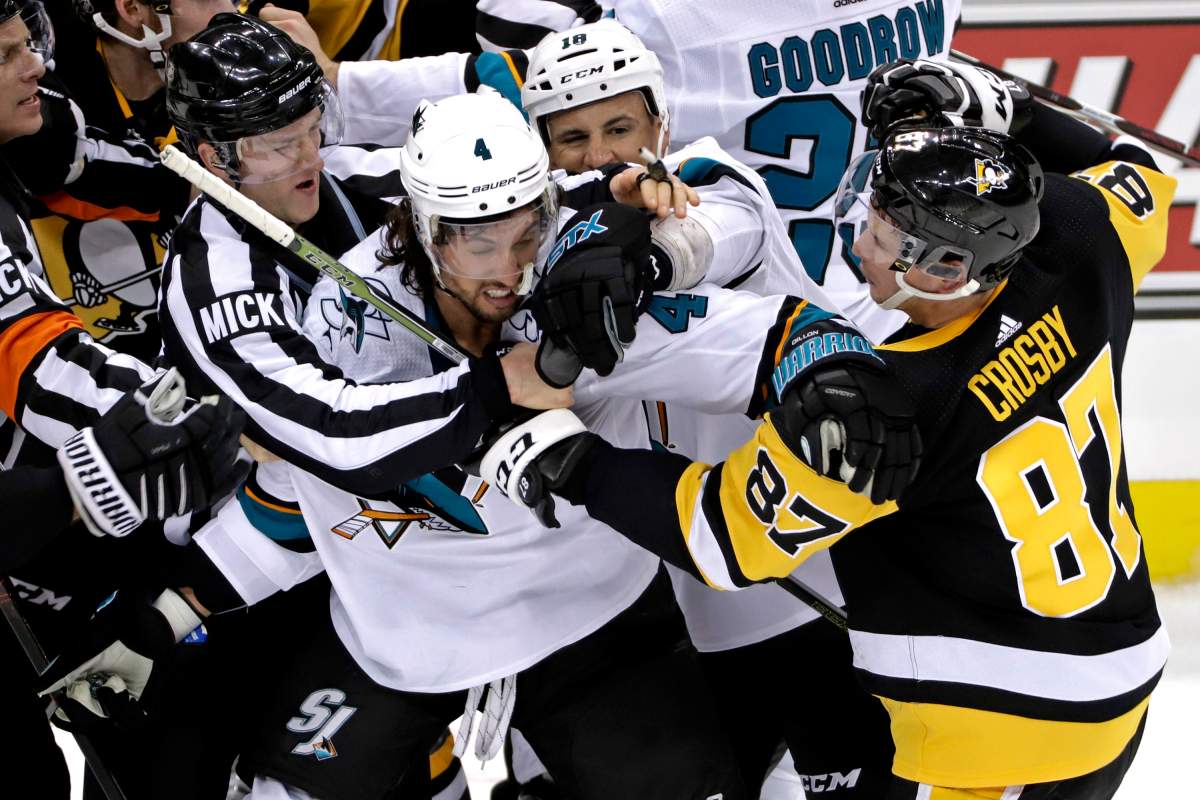 Pittsburgh Penguins’ Sidney Crosby (87) and San Jose Sharks’ Brenden Dillon (4) fight as Sharks’ Micheal Haley (18) intervenes during the third period of an NHL hockey game in Pittsburgh, Thursday, Feb. 21, 2019. (AP Photo/Gene J. Puskar)