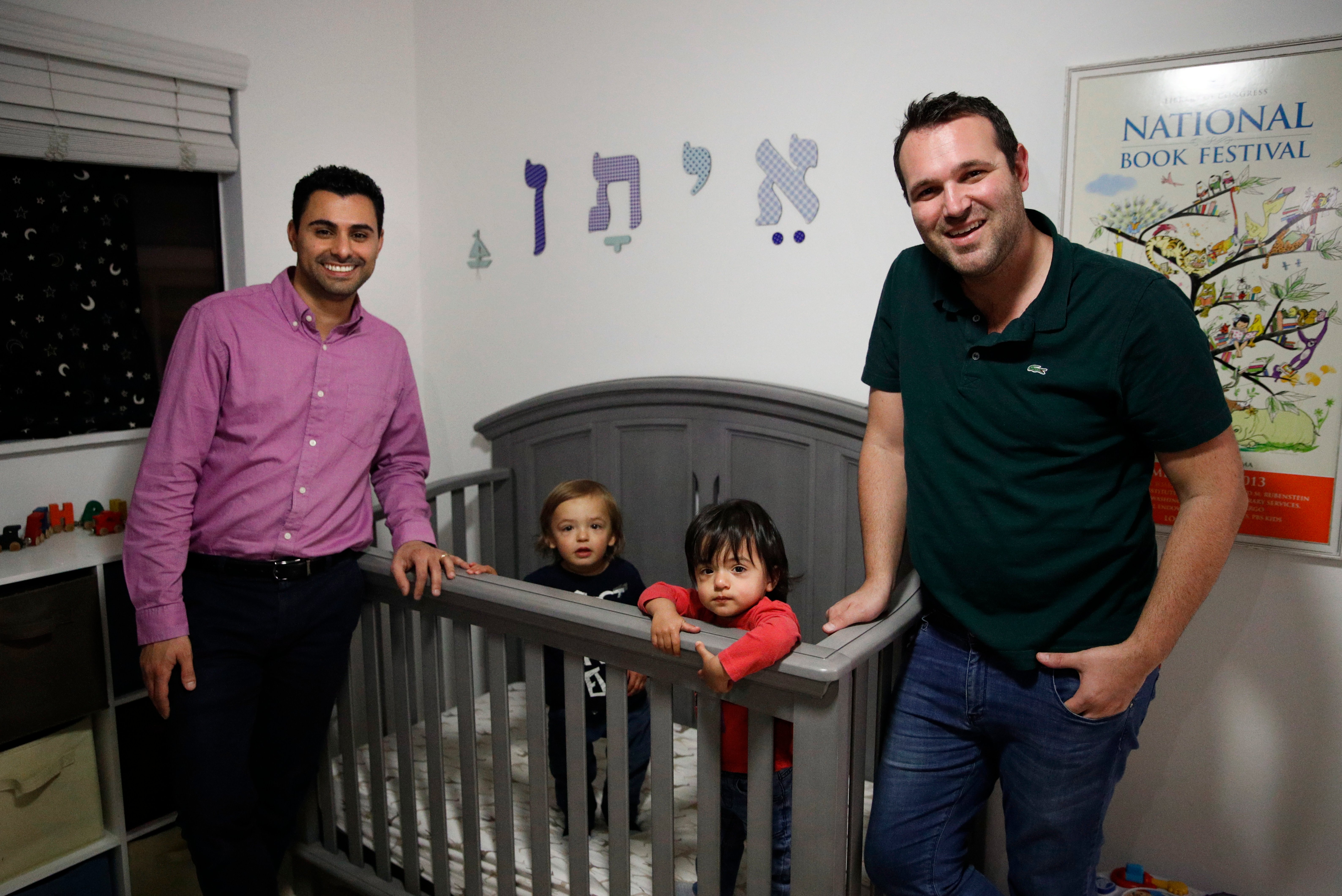 In the Tuesday, Jan. 23, 2018 file photo, Elad Dvash-Banks, left, and his partner, Andrew, pose for photos with their twin sons, Ethan, center right, and Aiden in their apartment in Los Angeles. 