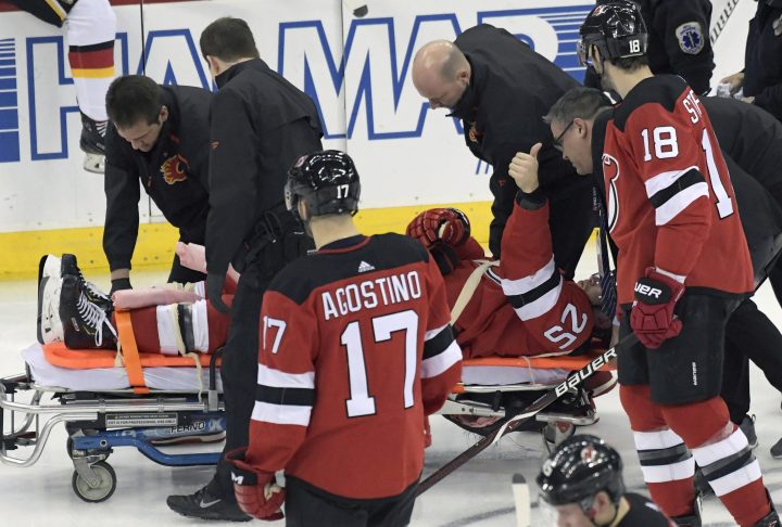 New Jersey Devils defenseman Mirco Mueller gives a thumbs-up sign as he is wheeled off the ice on a stretcher after being injured during the third period of an NHL hockey game against the Calgary Flames Wednesday, Feb. 27, 2019, in Newark, N.J. The Flames defeated the Devils 2-1.