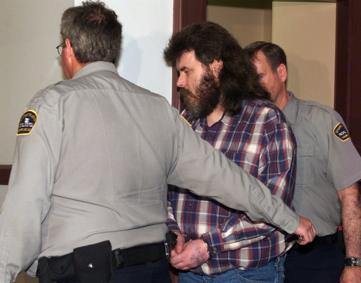 Convicted serial killer Michael Wayne McGray is escorted into provincial court in Halifax on Monday, May 28, 2001. McGray faces first degree murder charges in the 1985 death of 17-year-old Elizabeth Gale Tucker. 