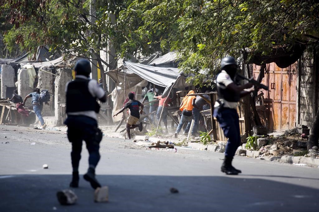 National police shoot at protesters demanding the resignation of Haitian President Jovenel Moise near the presidential palace in Port-au-Prince, Haiti, Wednesday, Feb. 13, 2019.